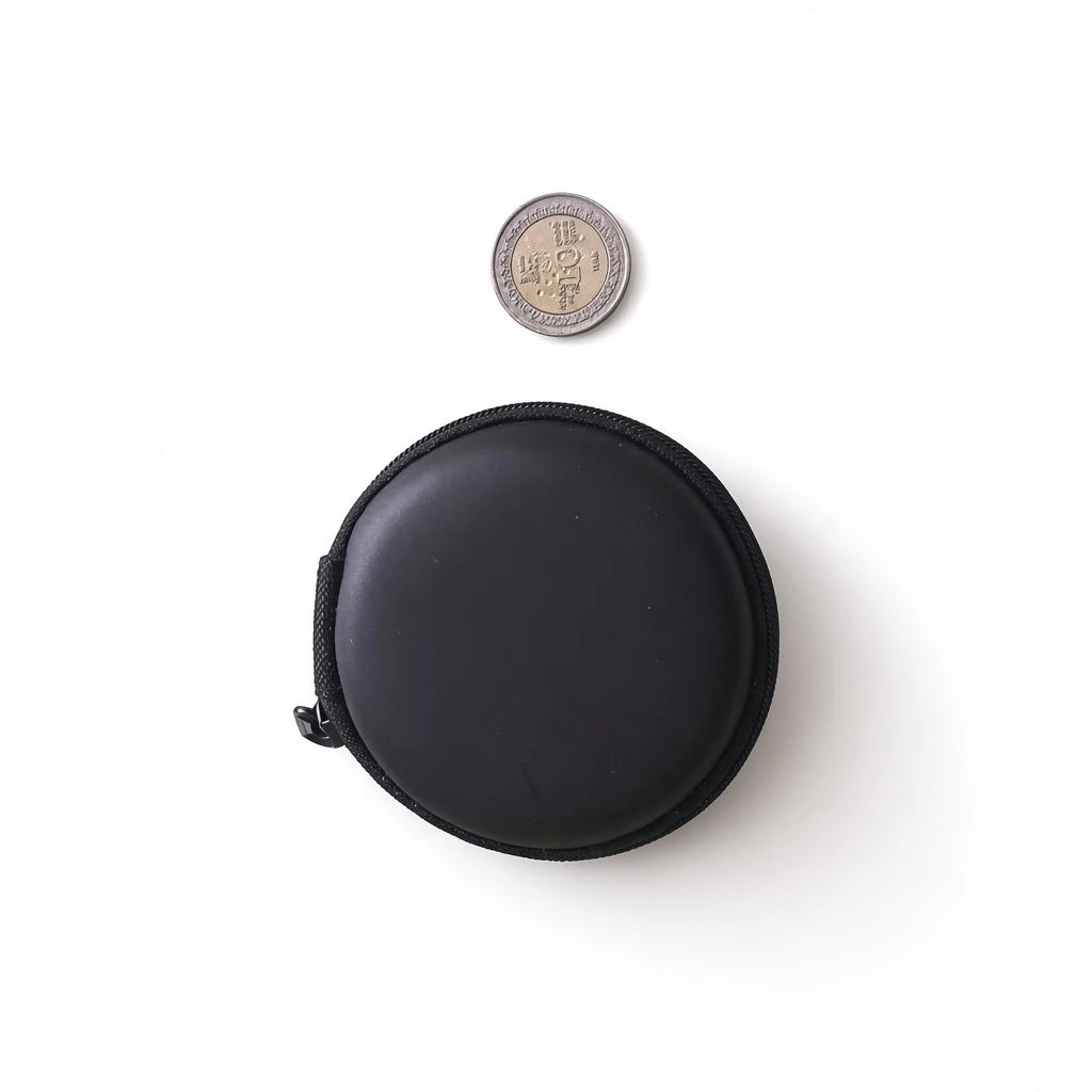 Compact black round hard shell earphone pouch next to a Sri Lankan coin showing portable mini size.